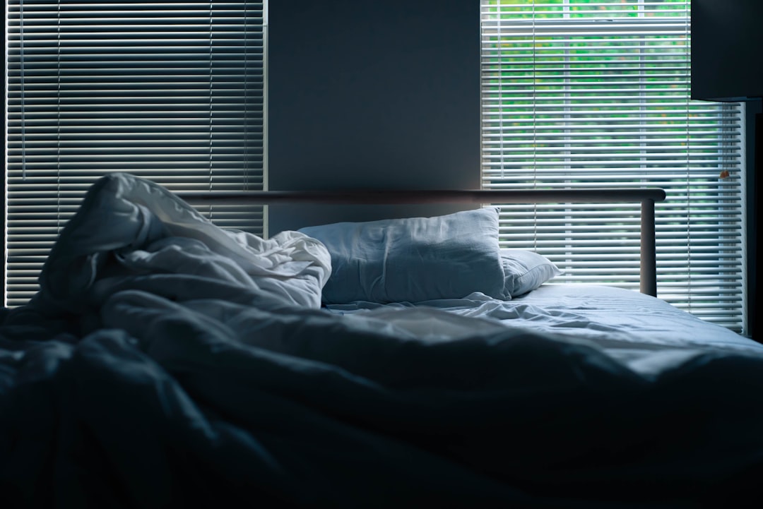 blue and white pillow on white bed